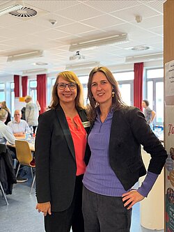 VHS Leiterin und Integrationsbeauftragte der Stadt Pinneberg stehen zusammen und lächeln in die Kamera